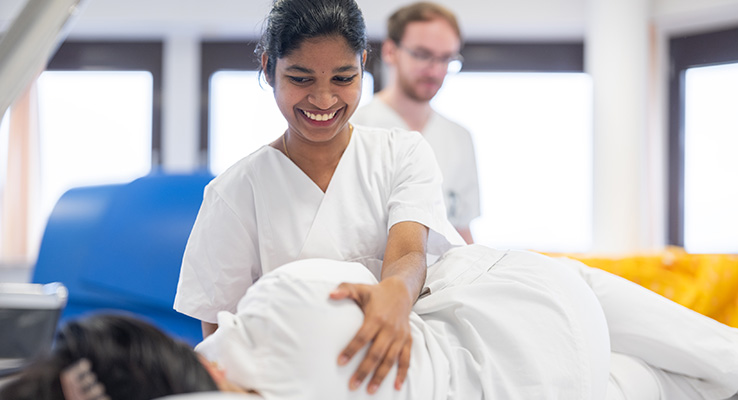 Praktische Ausbildung in der Pflege Pflegeschülerin führt unter Anleitung eine fachgerechte Lagerung einer Patientin durch.
