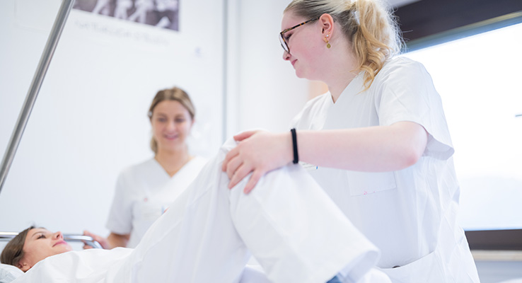 Pflegeausbildung im Klinikum Kulmbach – Mobilisation von Patienten Pflegeschülerin übt unter Anleitung einer Praxisanleiterin die Mobilisation einer Patientin im Klinikum Kulmbach.