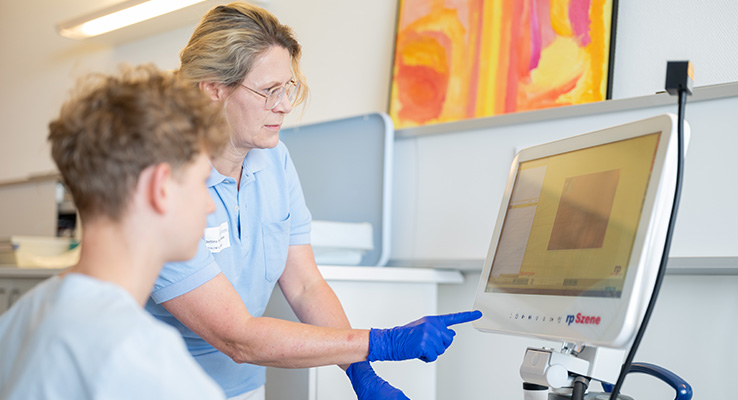 Moderne Diagnostik in der Logopädie Logopädin erklärt einem Praktikanten die Auswertung einer computergestützten Schluckdiagnostik.