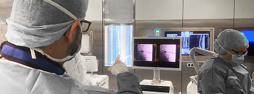 Intraoperative Bildgebung in der Neurochirurgie Ärzte betrachten Bildaufnahmen auf einem Monitor im Operationssaal